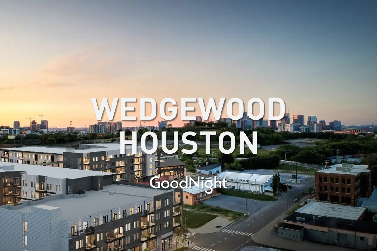 This image presents modern apartment buildings set against a vivid sunset sky, with the Nashville city skyline clearly visible in the distance. The scene captures an urban, communal ambiance, suggesting shared spaces elevated above the city—ideal for group gatherings.
